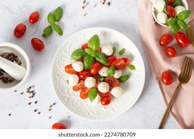 caprese salad on a white background. mozzarella and cherry tomatoes. Salad Caprese with tomato, mozzarella and basil, top view - Powered by Shutterstock