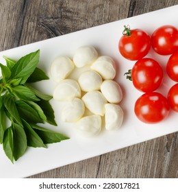 Caprese salad in shape of Italian flag on the white plate
