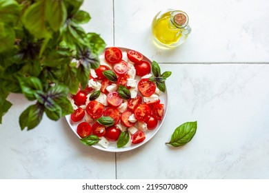 Caprese Salade Served In A Plate Under A Basil Plant, Home Garden Concept, Top View