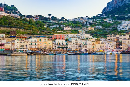 Capri, Italy - April 23, 2018: Marina Grande After Sunset, Capri Island, Italy. Illuminated Streets Of City Are Reflected In Calm Sea.