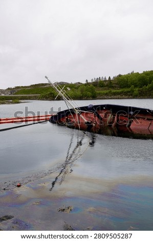Capsized cargo vessel Torvang's bow above calm waters in Hendvaagen bay, Norway.