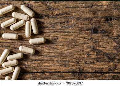 capsule pill on grunge wooden table. 