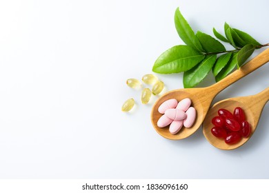 Capsule and vitamin organic supplements good for health in wood spoon on white background with copy space, medicine and drug concept - Shutterstock ID 1836096160