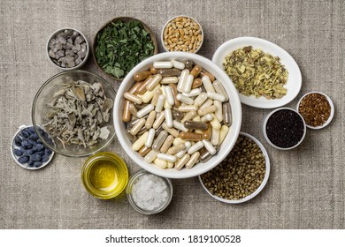Capsules with dietary supplements. Ingredients for food supplements, minerals, oil and herbs in plates - Shutterstock ID 1819100528