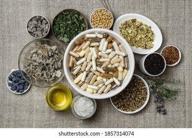 Capsules with dietary supplements. Ingredients for food supplements, minerals, oil and herbs in plates - Shutterstock ID 1857314074