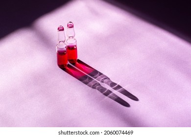 Capsules With Pink Liquid. Vitamin B Medicine In Capsules On A Purple Background. 