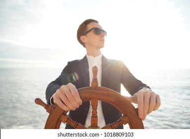 Captain. Businessman Holding Hand On Ship Rudder.