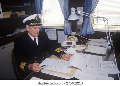 The Captain Of The Ferry Bluenose Doing Paperwork At His Desk, Maine