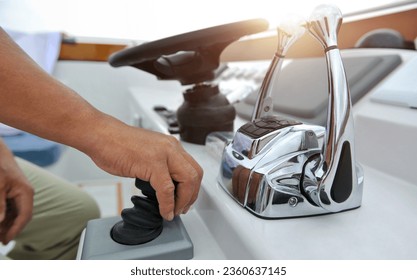 Captain hand at the helm while driving yacht - Powered by Shutterstock