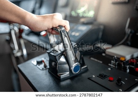 Captain hand holding throttle control or engine control lever on boat dashboard with GPS navigation and marine radar in wheelhouse or ship bridge. Speed adjustment instrument for seafaring technology