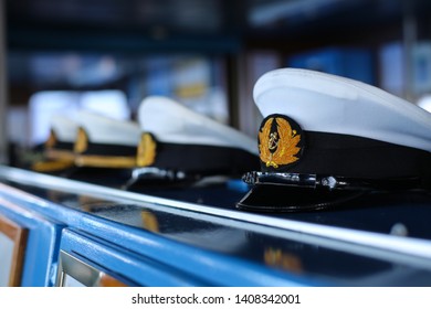 Captain hats with anchor emblem on the wooden shelf