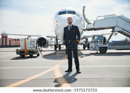 Captain standing while his plane preparing for flight