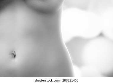 caption of nude belly to breasts of model posing in black and white