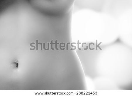caption of nude belly to breasts of model posing in black and white