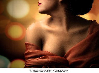 Caption of womans half head tilted sideways and chest covered with red clothing