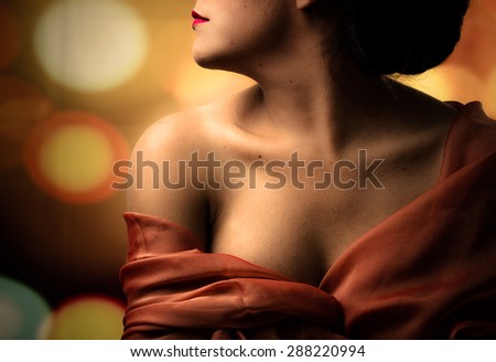 Caption of womans half head tilted sideways and chest covered with red clothing