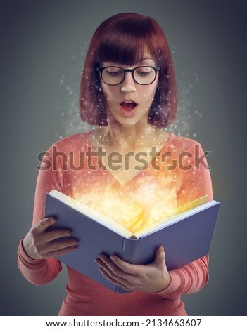 Captivated by an unexpected plot twist. A cropped shot of a young adult reading a book with glowing pages.