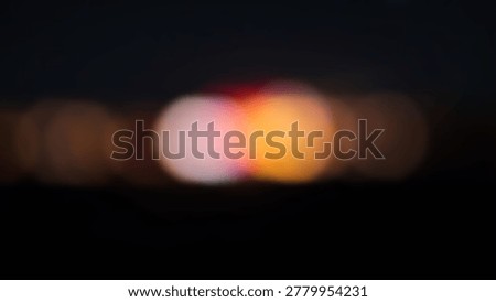 A captivating abstract image featuring bokeh lights. The blurred background showcases vibrant colors, creating a visually appealing and artistic composition. The dark backdrop enhances the luminosity.