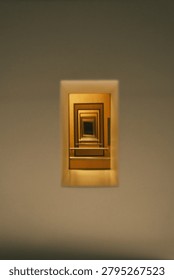 A captivating abstract image featuring a series of receding golden rectangular frames, creating an illusion of an infinite tunnel or portal.