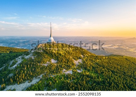 The captivating aerial view showcases Jested mountain with its distinctive hotel and TV transmitter, surrounded by lush greenery and the expansive landscape of Liberec, Czechia.