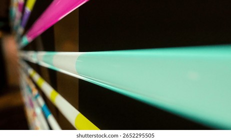 A Captivating Array of Multicolored Light Tubes Arranged Horizontally on a Solid Black Background.