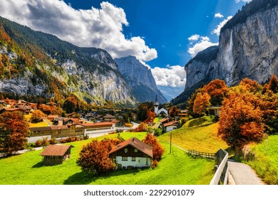 Captivating autumn view of Lauterbrunnen valley with gorgeous Staubbach waterfall and Swiss Alps at sunset time. Lauterbrunnen village with autumn red foliage, Berner Oberland, Switzerland, Europe. - Powered by Shutterstock