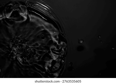 A captivating black and white image capturing the essence of dark water, featuring bubbles and ripples in dynamic movement, creating an abstract visual experience.