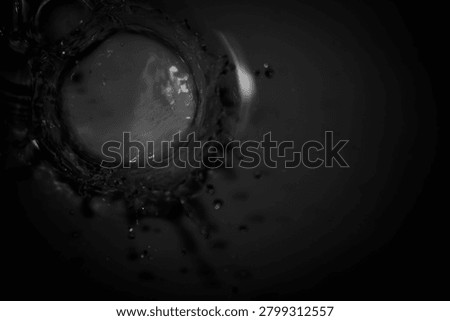 Captivating black and white image capturing the intricate beauty of water splashing in circular motion. Perfect for creative projects and visual exploration.