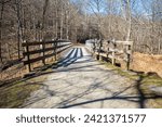 A captivating bridge guides the way with prominent lines towards the scenic footpath along the Youghiogheny River Trail at Cedar Creek Park in Westmoreland County, Pennsylvania.