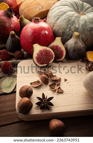 A captivating frontal view of vibrant autumnal fruits, including figs, hazelnuts, pomegranates, and pumpkin, set against a captivating vertical backdrop.