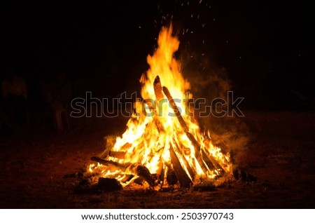 Captivating image of a vibrant bonfire, with flames dancing against the night sky