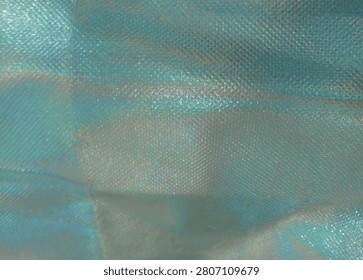 Captivating Iridescent Textile Texture

This image highlights a stunning close-up of an iridescent fabric, revealing its unique texture and mesmerizing color play. The soft sheen glimmers in hues of blue and green, creating a dynamic visual as light interacts with the surface. Fine patterns weave throughout the material, adding depth and interest. Ideal for fashion, accessories, or artistic projects, this fabric stands out for its elegant and luxurious quality. Its captivating nature makes it perfect for designs that aim to evoke creativity and charm, enhancing any decorative or wearable item beautifully.