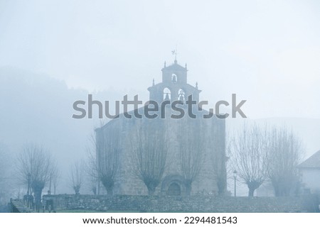 Captivating and mysterious photo of a foggy morning in Cantabria, Spain, featuring a beautiful church surrounded by ethereal mist.