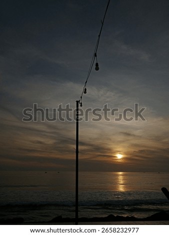 A captivating ocean sunset with a string of lights silhouetted against the sky, creating a serene and moody atmosphere. Perfect for travel, events, or peaceful escape themes. #CoastalSunset