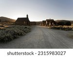  A captivating perspective captured while looking down a street near the church in the historic town of Bodie, CA. The deserted street is lined with vintage buildings, echoing the bygone era.