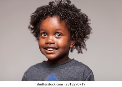 Captivating studio portrait of a young Ethiopian girl radiating pure joy, as she indulges in playful silliness and showcases her delightful expressions on a white seamless backdrop.