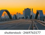 Captivating view of the iconic 6th Street Bridge in Los Angeles at sunset, with the city’s dynamic architecture silhouetted against the warm hues of the evening sky.