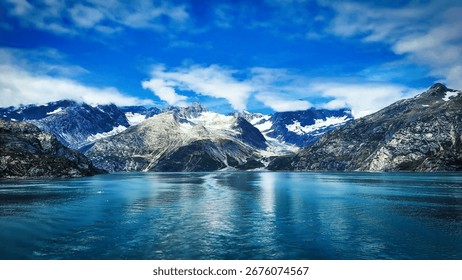 Captivating view of a mountain range reflected on a tranquil body of water surrounded by a beautiful blue sky
