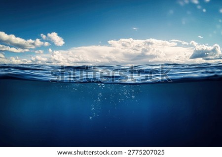 A captivating view of the ocean, split between the underwater world and the sky above, showcasing the beauty of both realms.