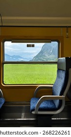 The Captivating View Out the Train Window: Bright Green Meadows and Majestic Mountains on a Sunny Day. 