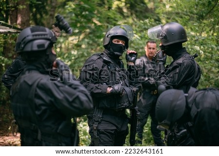 The capture group is preparing for the task. Riot police in uniform for surgery. Men in the uniform of a riot policeman with weapons in their hands