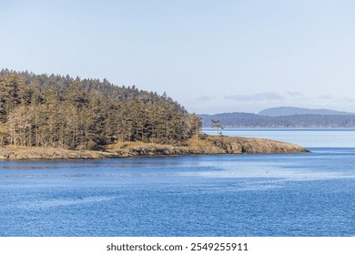 Capture of the Gulf Islands in British Columbia, showing a serene coastal landscape with calm blue waters and lush evergreen forests. - Powered by Shutterstock