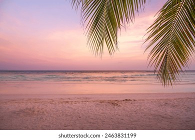 Capture the mesmerizing beauty of a beach sunset with this stunning photograph. As the sun dips below the horizon, the sky is painted in a breathtaking palette of warm oranges, pinks, and purples. - Powered by Shutterstock