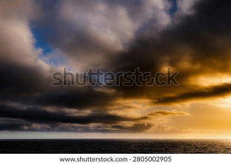 Capture the stunning interplay of light and clouds during sunset over the ocean
