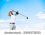 Capture the thrill of golf with this high-resolution image showcasing a golfer in mid-swing on a lush green fairway. The golfer, dressed in modern athletic wear, demonstrates perfect form as they stri