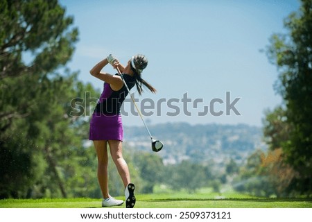 Capture the thrill of golf with this high-resolution image showcasing a golfer in mid-swing on a lush green fairway. The golfer, dressed in modern athletic wear, demonstrates perfect form as they stri