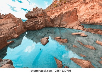 Capture the tranquil beauty of a secluded coastal cove with striking azure waters, rugged sandstone cliffs, and bright blue skies, perfect for a peaceful and scenic escape. - Powered by Shutterstock