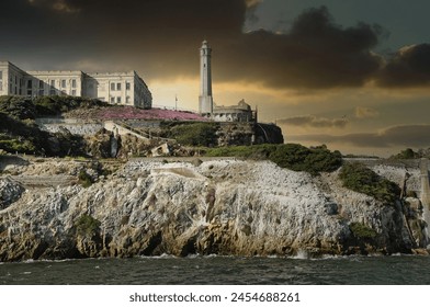 Captured at the historic Alcatraz Island, this image showcases the Alcatraz lighthouse standing stoic against a fiery sunset, with seagulls soaring in the golden sky. - Powered by Shutterstock