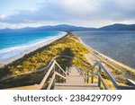 Captured on the serene shores of Bruny Island, this photo showcases the graceful curve of a tranquil neck of land, where the Tasman Sea meet the tranquil beauty of the island