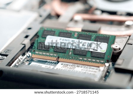 Captures the process of installing a new memory stick or RAM, shown at a 45-degree angle in the slot before being pressed down. Perfect for 